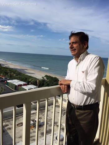 Virender Sharma, Ph.D., looking out over the beach city in Miami, Florida.